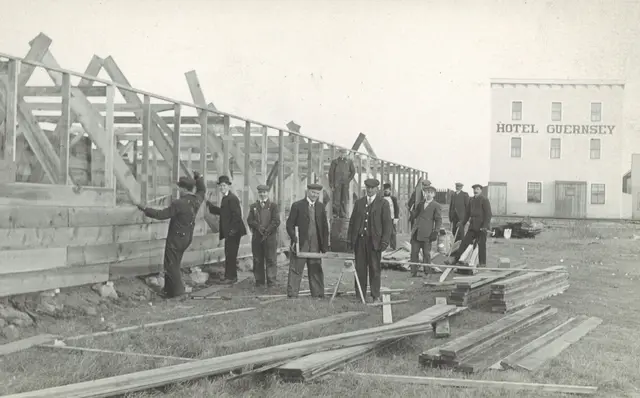 Men building a frame structure near Hotel Guernsey
